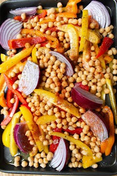 chickpeas, peppers and red onions on a baking tray 