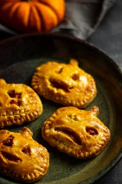 A plate of 4 Spooky Butternut Squash & Red Pepper Empanadas.