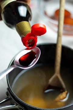 Soy sauce being added to the ramen stock. 