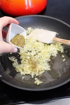 onion being cooked in a pan with oregano