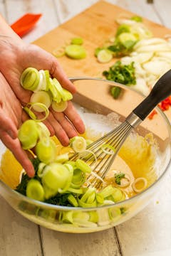 The chopped veg being added to the pakora batter. 