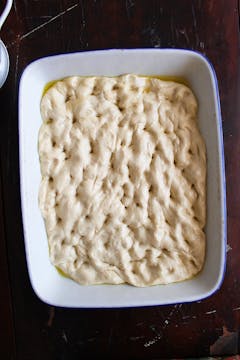 dough on baking tray with holes to knock out the air