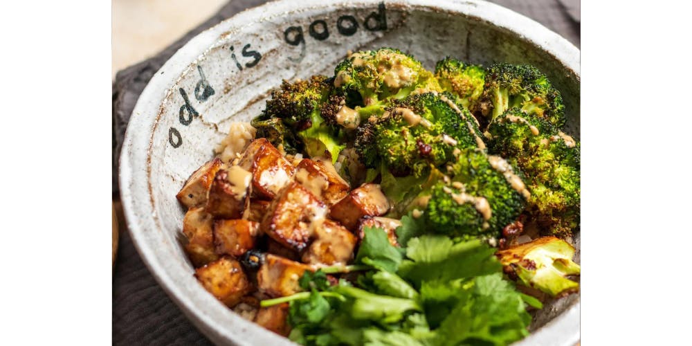 roasted broccoli with miso tofu in a white bowl