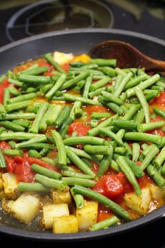 green beans and tomatoes added to the to pan