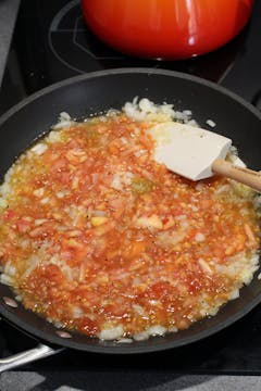 frying pan with onions and chopped tomatoes