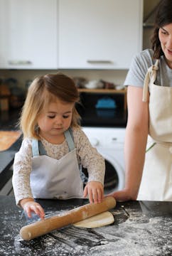 little girl rolling out dough