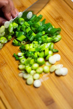 Spring onions being sliced finely.