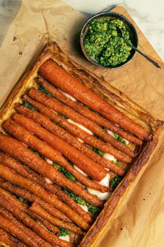 The tart served with a bowl of pesto on the side.