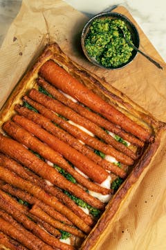 The tart served with a bowl of pesto on the side. 