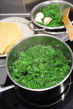 Kale leaves being blanched in boiling water. 