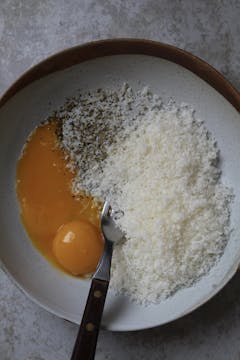 egg yolks with half of the finely grated parmesan, black pepper and fork for mixing