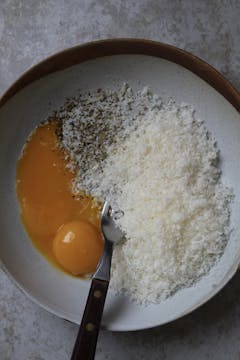 egg yolks with half of the finely grated parmesan, black pepper and fork for mixing 