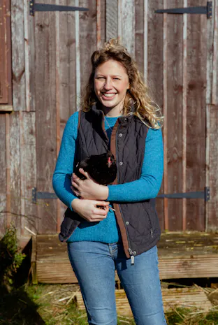 a farmer holding a hen