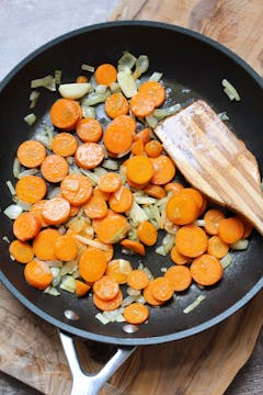 carrot and other ingredients being cooked in a pan