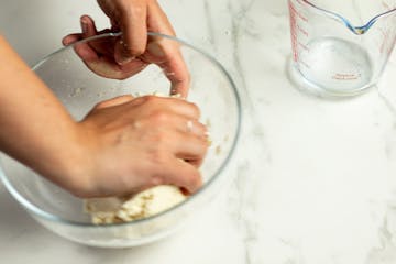 kneading the dough in a bowl