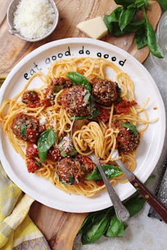 vegan meatballs served with spaghetti and basil leaves