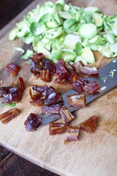 chopped dates and shredded brussels sprouts in chopping board 