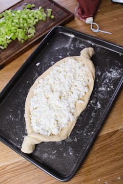 dough with cheese on baking tray