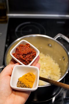 image of herbs being added to pan