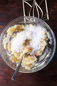 mashed potatoes with parmesan and seasonings in mixing bowl 
