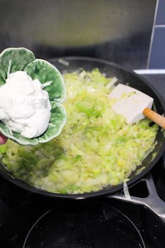 image of creme fraiche being added to leek