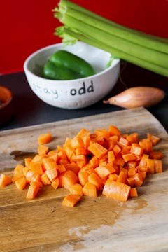 chopped up carrot with celery in the background