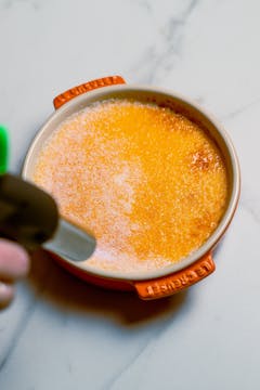 caster sugar on top of the baked Crème Brûlée, blowtorch caramelising the sugar