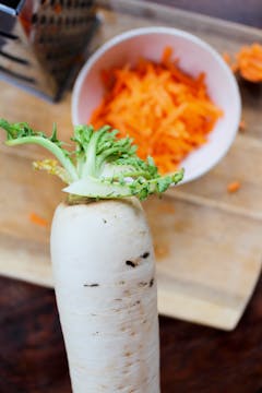 mooli radish with shredded carrots in the background