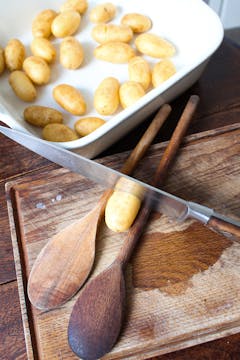 Potatoes being cut with knife