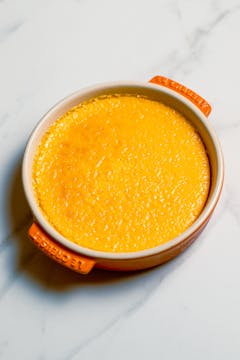 baked Seville Orange & Cardamom Crème Brûlée on a dish thats orange