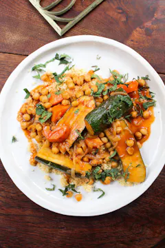 coyrgettes with chickpeas and couscous on white plate