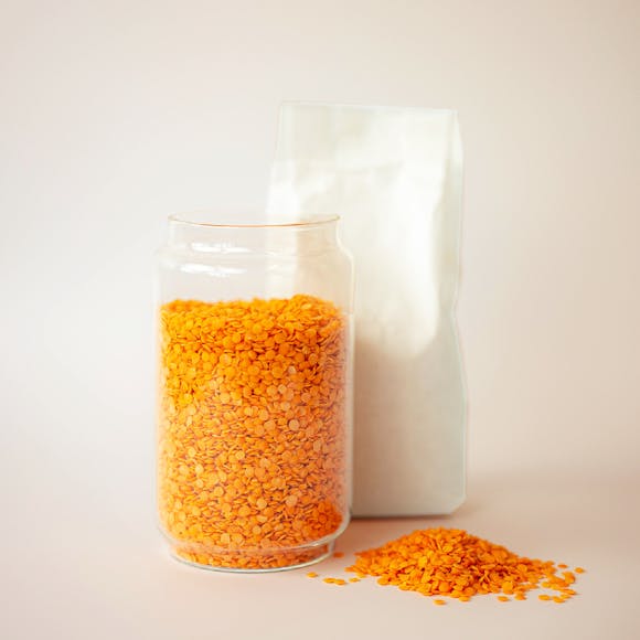 Glass jar filled with red lentils.