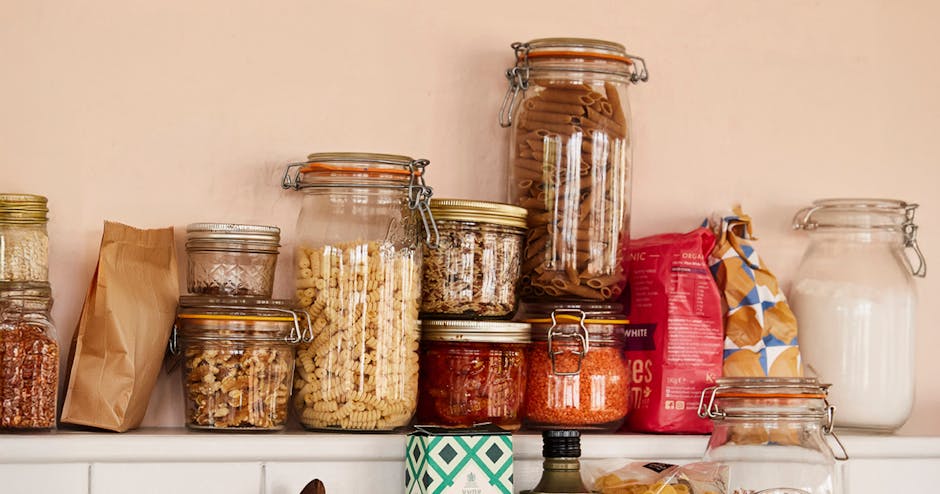 Glass jars on a shelf filled with pantry staples.