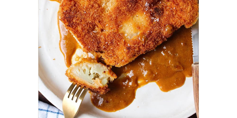 Cauliflower katsu curry on a white plate