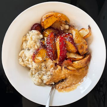 roasted plum and apple porridge in a white bowl 