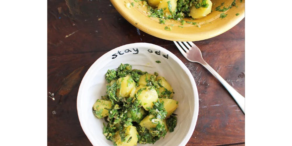 Salsa verde potato salad in a white bowl