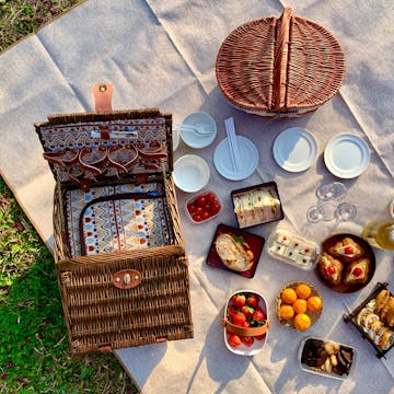picnic basket on a blanket with picnic food