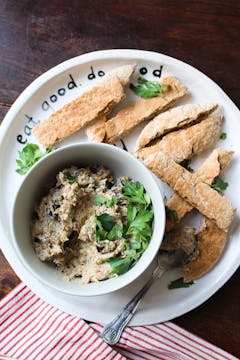 Aubergine dip in small bowl with pitta bread on the side