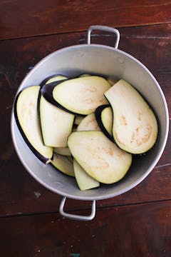 sliced and salted aubergines in a pot