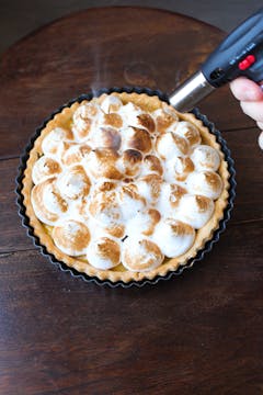 blow torch is being used to cook the meringue