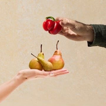 Hands holding peppers and pears