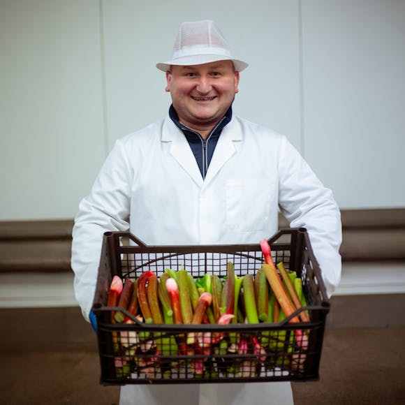 Grower holding a box of rhubarb.
