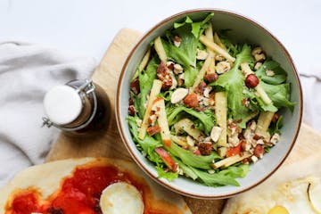 side salad with olive oil next to it 