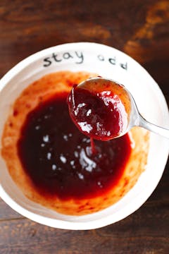 cranberry sauce and bbq sauce being mixed together in a bowl