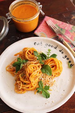 served roasted tomato sauce spaghetti on a plate and roasted tomato sauce on jar next to the plate 