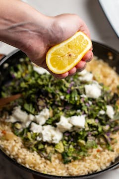 all the ingredients on pan and half of fresh lemon being squeezed