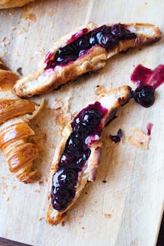 croissant halves with compote on chopping board