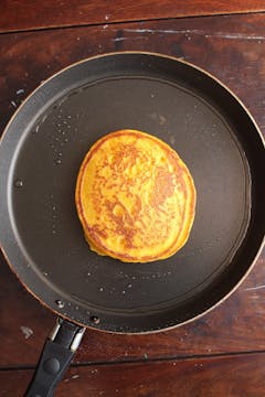 a singular pancake cooked on a frying pan