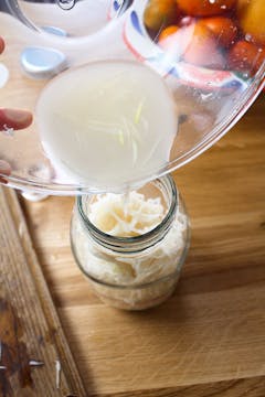liquid being poured into a jar with mooli radish 
