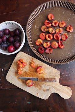 Plums cut in chopping board